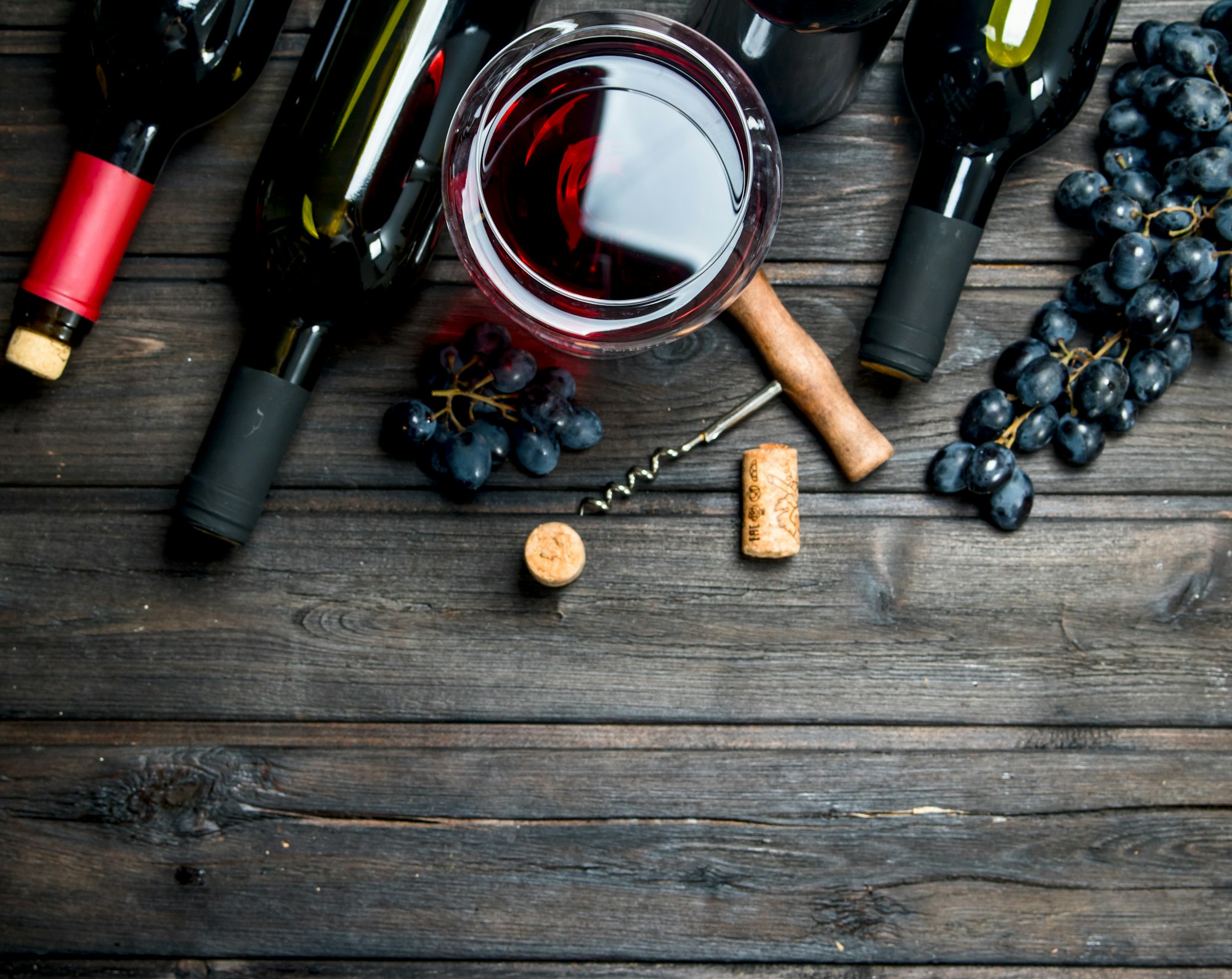Wine background. Red wine with grapes and corkscrew.